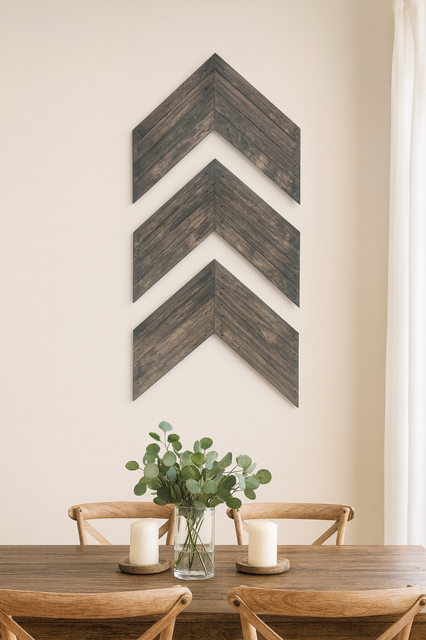 Rustic gray chevron wall art set of 3 arranged vertically on dining room wall above wood table.