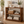 Early American wooden console table styled in an entryway with baskets, books, plants, boots, and home decor