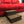 Front angle of a rustic wooden 2-step stool in dark walnut placed by a sofa.