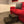 Handmade wooden 2-step stool in dark walnut finish placed next to a red sofa.