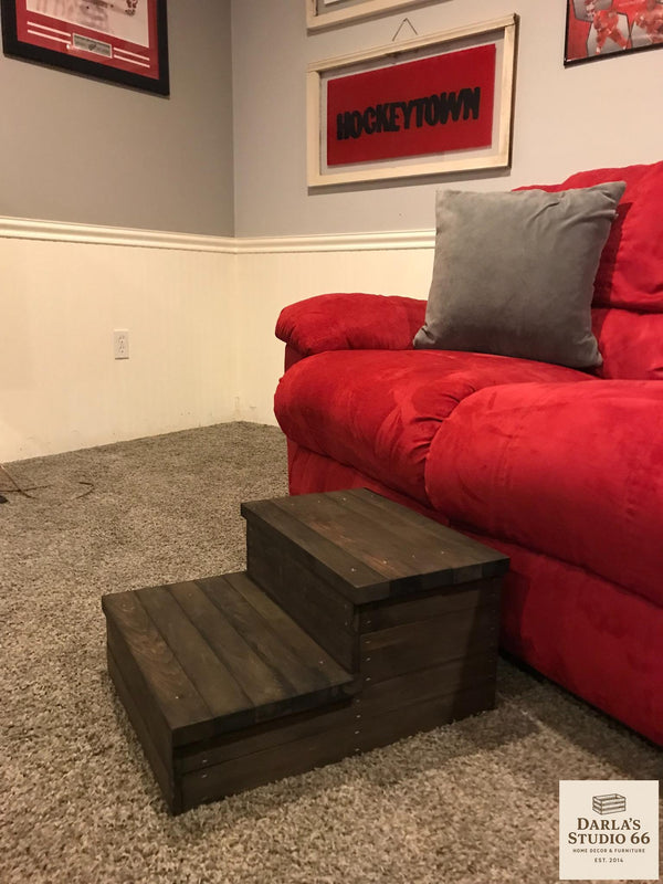 Handmade wooden 2-step stool in dark walnut finish placed next to a red sofa.