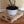 Wooden pallet stand holding potted plant on hardwood floor