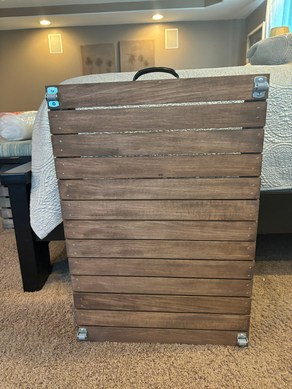 Bottom view of wooden under-bed storage drawer showing rolling casters