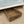 Rustic wooden under-bed storage drawer shown under white bed frame