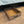 Rustic wooden under-bed storage drawer with black handle pulled out on carpet