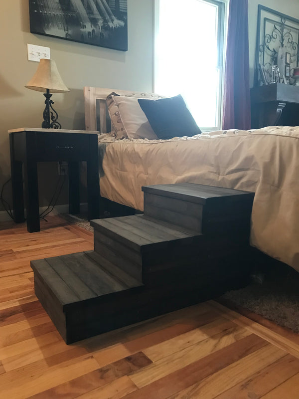 Closeup of rustic wooden 3-step pet stairs in dark walnut stain on hardwood floor.