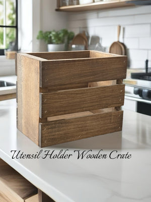 Empty rustic wooden utensil holder crate on a kitchen counter