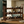 Early American wooden wine rack holding wine bottles on a rustic table in a dining or bar area