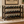 Dark Walnut wooden wine rack holding 18 wine bottles in a rustic dining room or home bar setting