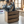 Rustic wooden utensil holder crate filled with cooking utensils on counter