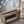Farmhouse style wooden CD holder crate on wood floor with string lights in background.