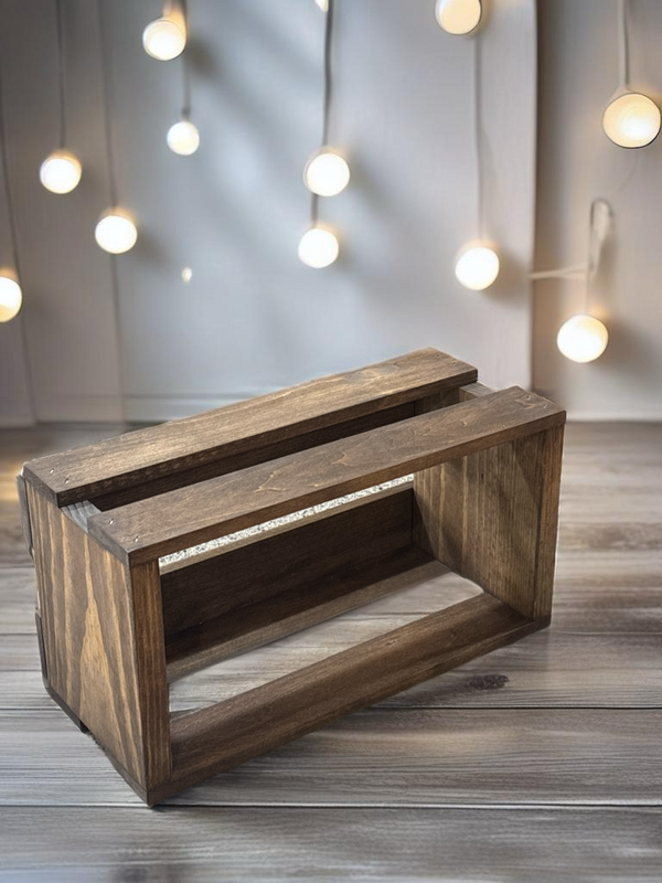 Farmhouse style wooden CD holder crate on wood floor with string lights in background.