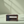 Dark stained wooden CD holder crate on light green table with sunlight shadows.