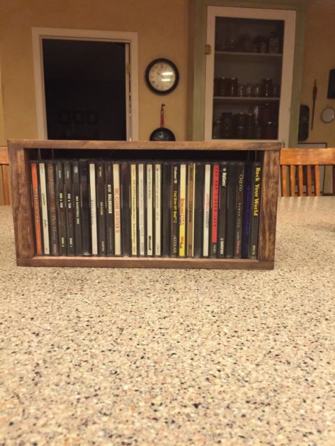 Rustic CD holder wood crate filled with music CDs displayed on kitchen counter.