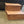 Cherry stained two-step wooden pet stairs beside couch on carpet