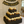 Dark stained 3-tier wooden cupcake stand filled with cupcakes at a 50th anniversary celebration.