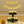 Three-tier dark wood cupcake stand displayed at a 50th anniversary celebration with cupcakes and decorations.