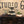 Rustic three-tier dark cupcake stand loaded with cupcakes against a Studio 66 event backdrop.