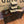 Dark wooden cupcake stand filled with cupcakes at a rustic wedding dessert table with candles and décor.