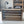 Wooden DVD holder crate on tabletop with bookshelf in background.