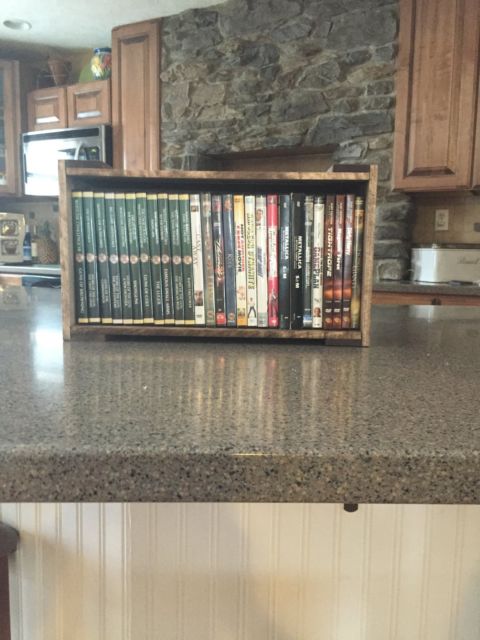 Handcrafted DVD storage crate holding movie collection on kitchen counter.