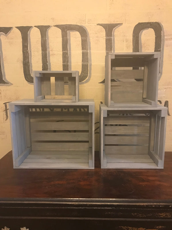 Set of 4 empty gray rustic nesting crates in different sizes on a dresser