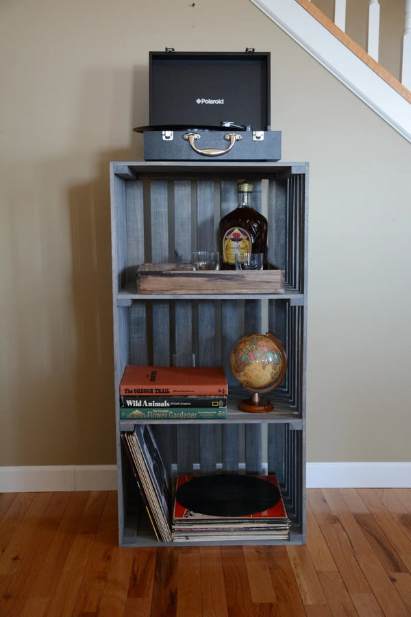 Front view of rustic gray 3-tier record stand styled with books, globe, and record player.