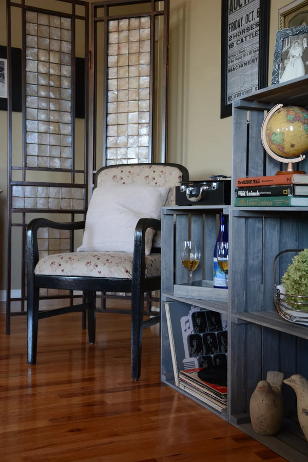Gray stained 3-tier record stand shown in a cozy living room with books and globe.