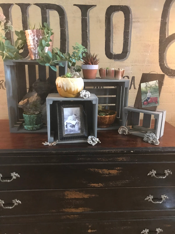 Set of 4 empty gray rustic nesting crates in different sizes on a dresser