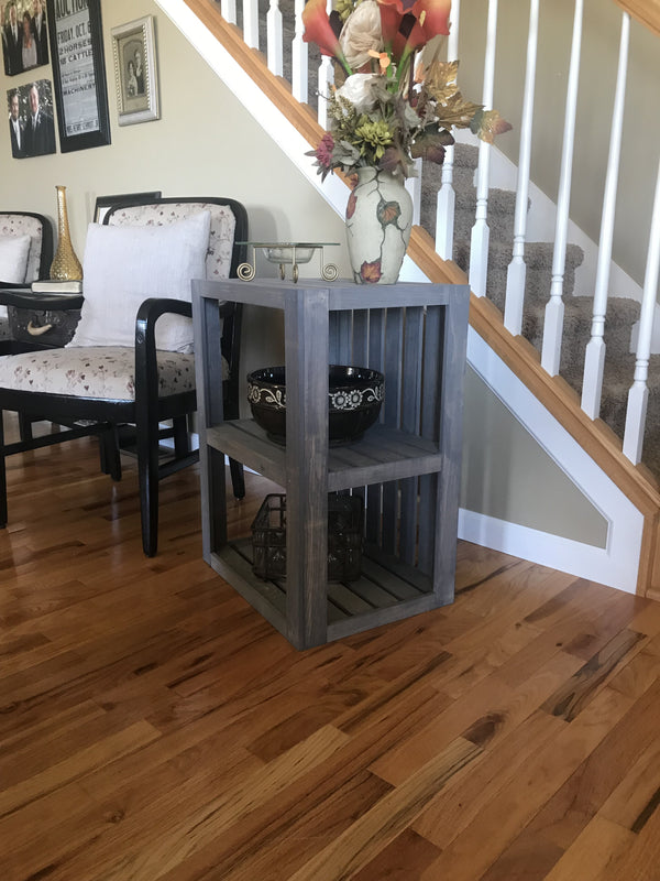 Farmhouse gray wood end table with flowers and ceramic bowl.