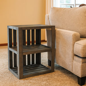Rustic gray end table beside sofa in farmhouse style living room.