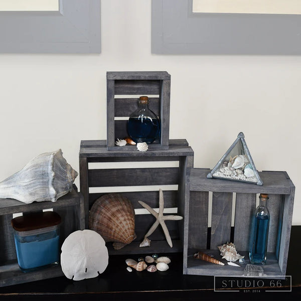 Rustic gray wooden nesting crates styled with seashell and nautical decor.