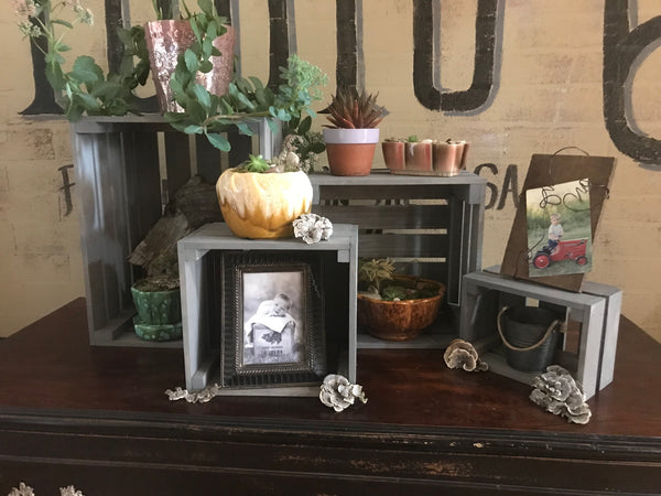 Gray nesting crates used as shelves for picture frames and family photos