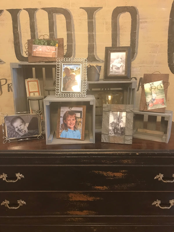 Rustic gray nesting crates with framed photos and farmhouse décor accents