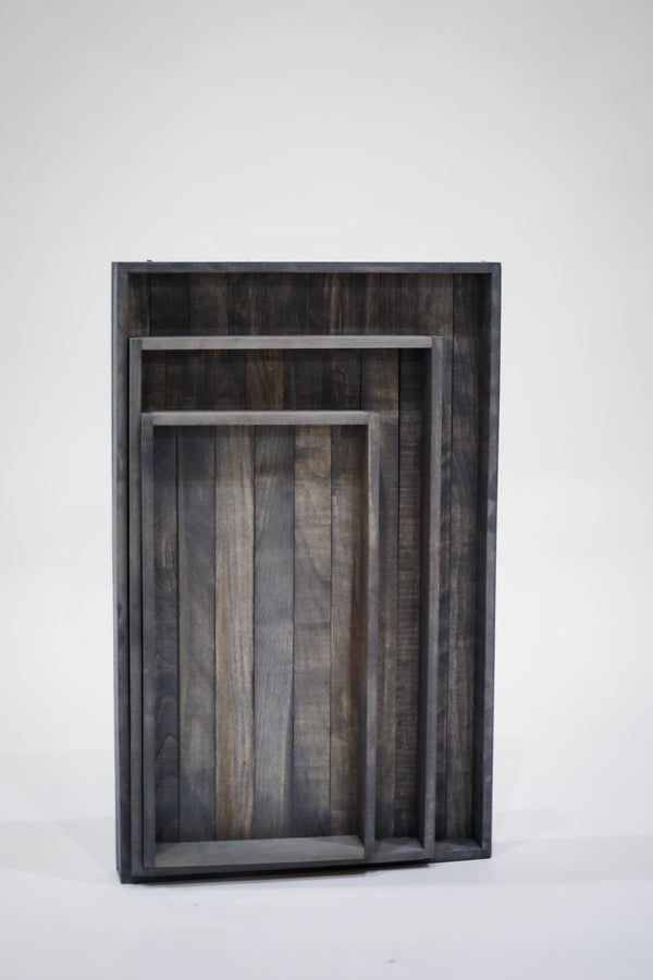 Set of three nesting gray wooden trays shown stacked together.