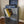 Two-tier gray wooden turntable stand with record player and vinyl storage.