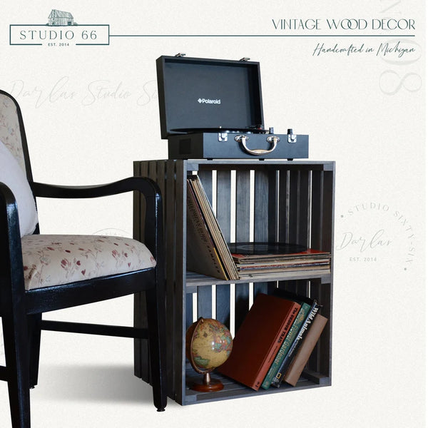 Farmhouse style gray turntable stand beside vintage chair with records.