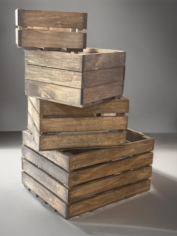 Wooden farmhouse nesting crates stacked decoratively on rustic wood floor.