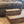 Side view of a rustic medium brown stained 2-step wooden stool on carpet.