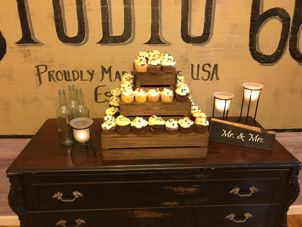 Wooden cupcake display stand in medium finish holding cupcakes for an event