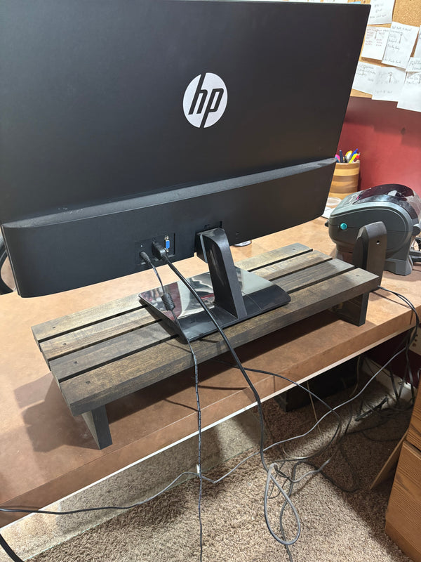 Rustic dark wood 24-inch monitor stand holding HP desktop, cable storage underneath.