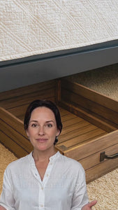 Video showcasing rustic wooden under-bed storage drawer with wheels, easy pull-out design, and black metal handle
