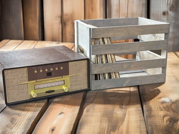 Rustic gray stained wooden record storage crate beside a vintage stereo on wooden table.