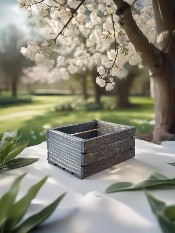 Dark stained small wood crate outdoors with spring flowers, farmhouse decor.