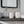 Rustic small gray tray used as bathroom counter organizer with decor items.