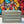 Vintage blue stained wood crate placed in front of colorful graffiti wall, rustic and urban.
