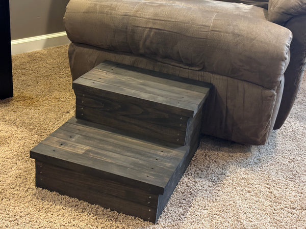 Handmade wooden 2-step stool in vintage dark stain next to recliner, rustic pet or toddler step.