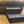 Vintage dark stained 2-step wooden stool beside a couch on carpet, rustic pet stairs or child step stool.