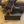 Small dog climbing on a vintage dark wooden 2-step stool, rustic handmade pet stairs.