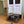 Small dog resting inside handcrafted medium brown wooden pet bed